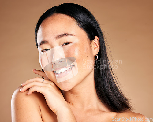 Image of Portrait, beauty and treatment with a model asian woman in studio on a beige background for natural skincare. Wellness, aesthetic or facial with an attractive young female posing to promote antiaging