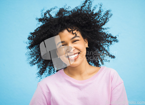 Image of Shake hair, happy face portrait and black woman with healthy shampoo hairstyle, studio beauty or facial skincare. Cosmetic makeup, spa salon and afro girl from Brazil isolated on blue background wall