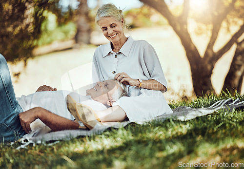 Image of Retirement, love and picnic with a senior couple outdoor in nature to relax on a green field of grass together. Happy, smile and date with a mature man and woman bonding outside for romance