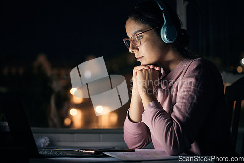 Image of Laptop, night and music with a student woman in her home for learning, education or development using the internet. Computer, research and elearning with a female pupil studying late in a dark house