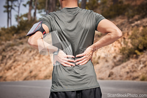 Image of Fitness, back pain and man in road with hands on hurt muscle for support with smartphone running tracker. Health, exercise and outdoor workout, runner with injury, tension or painful muscles on spine