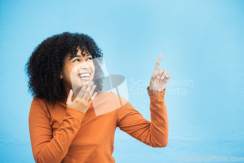 Image of Black woman, wow face and pointing hands in studio for news, announcement or notification by blue background. African gen z girl, young model and fashion with surprise hand sign with excited laugh
