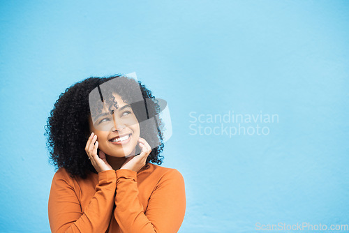 Image of Thinking, happy and mockup with a black woman on a blue background in studio for branding or product placement. Idea, smile and mock up with an attractive young female looking thoughtful on space