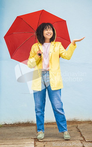 Image of Rain, black woman and umbrella in a city for travel, having fun and solo trip on wall background. Weather, happy and girl traveler enjoying rainfall, happy and smile for journey, experience and joy