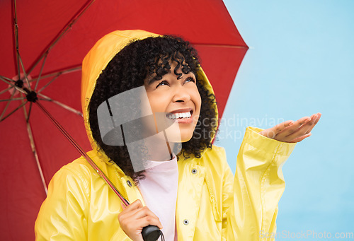 Image of Black woman, umbrella or hand catching rain on isolated blue background in Brazil city. Person, student or checking for weather water drops in rainfall anxiety, curious or wondering facial expression