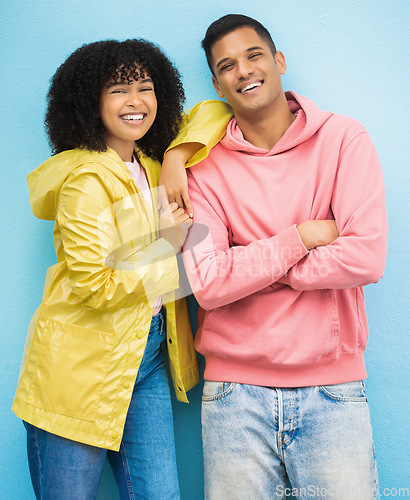 Image of Couple of friends, portrait or bonding on isolated blue background in fashion, trend or cool style clothes. Smile, happy man or black woman with afro hair, arms crossed or weather raincoat protection