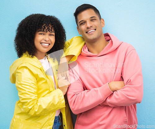 Image of Couple of friends, portrait and happy people on isolated blue background in fashion, afro hair trend and cool style clothes. Smile, man and black woman bonding with arms crossed or weather raincoat