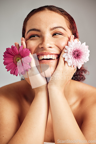 Image of Woman, flowers and studio headshot with smile for beauty, wellness or skincare with spring aesthetic by backdrop. Model, girl and carnation plant for cosmetic health, skin glow and happy for growth