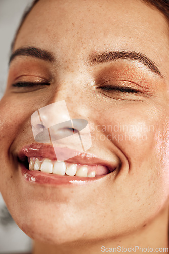 Image of Face, woman and smile in studio for makeup, skincare and wellness, content and joy or grooming. Happy, beauty and girl model laughing, skin and routine, care and hygiene for soft, smooth and perfect