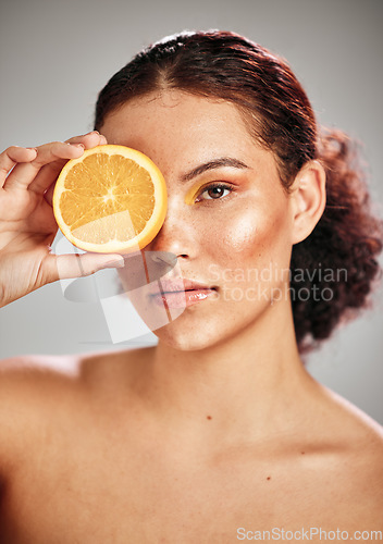 Image of Woman, orange eye and face portrait in studio for natural skin glow, cosmetics and dermatology. Facial makeup, health and wellness of aesthetic model person with vitamin c skincare fruit results