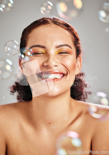 Image of Beauty, bubbles and face of woman with a smile in studio for skincare cosmetics, skin glow and dermatology. Natural facial makeup, health and wellness of aesthetic model with luxury body product