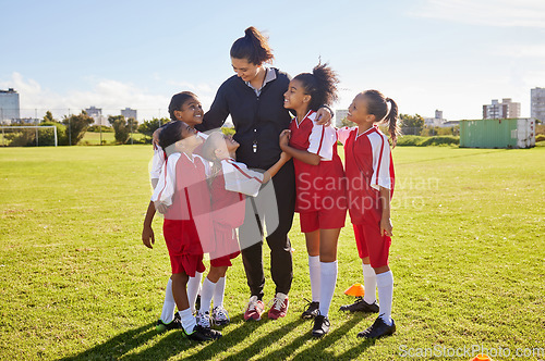 Image of Girl, soccer group and field with coach, team building hug and solidarity at sport training. Female kids, sports diversity and happy with friends, teamwork and football coaching with mentor woman