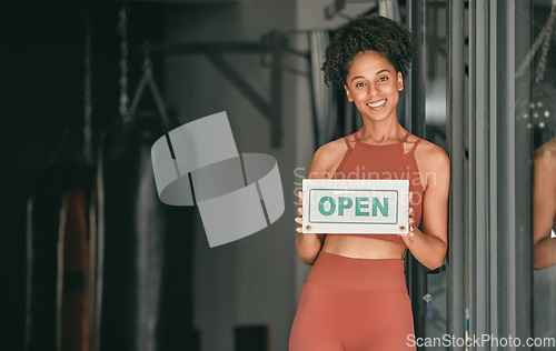 Image of Fitness, portrait or personal trainer at gym with an open sign for workout exercises or training. Manager, happy or healthy black woman with a friendly smile holding a board to welcome exercising