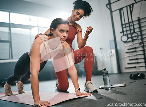 Image of Personal trainer, fitness and stopwatch with a black woman coaching a client in a gym during her workout. Health, exercise or training and a female athlete doing a plank with her coach recording time