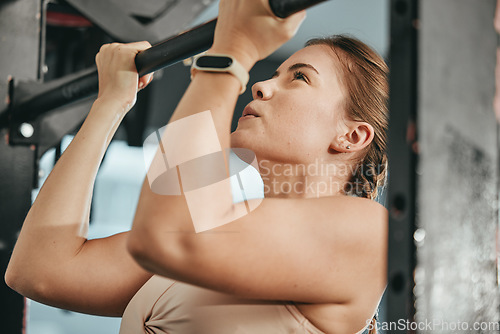 Image of Fitness, pull up and woman at gym for training, health and cardio, focus and power mindset. Exercise, chin up bar and girl at sports center for workout, muscle and bodybuilding for healthy lifestyle