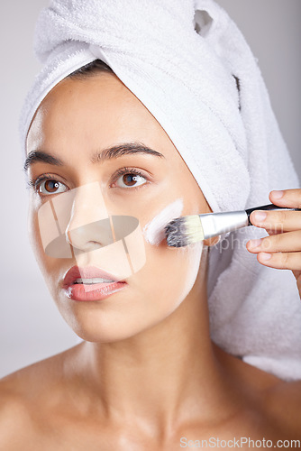 Image of Woman, makeup and brush in studio with towel for cosmetic beauty application, natural aesthetic and wellness. Model, skin health and self care facial for healthy radiant glow on face with skincare