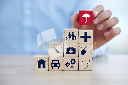 Image of Insurance, wood building blocks and sign with hand for home, healthcare and car on desk for security. Icon toys, finance and protection for home, medicine and health for investment in safety service