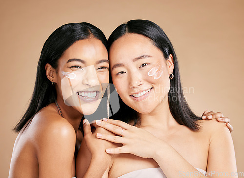 Image of Portrait, cream and diversity with model woman friends in studio on a beige background for skincare. Face, natural and wellness with a young female and friend posing to promote a cosmetic product