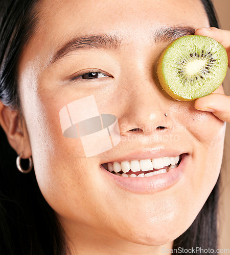 Image of Asian woman, smile and kiwi skincare portrait for facial skincare wellness, luxury organic product and happy dermatology. Model, face and fruits vitamins for natural cosmetics happiness or skin glow