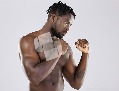 Image of Muscular, fight and black man with focus, training and determination with guy against grey studio background. Muscles, African American male fighter or athlete practice, power or endurance for energy