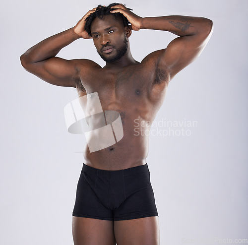 Image of Sports person, fitness and body of black man in studio for strong muscle and power. Health and wellness of a sexy male bodybuilder model in underwear with growth after exercise, workout and training