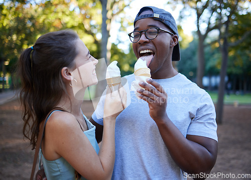 Image of Interracial, ice cream or couple of friends in a park walking on a fun romantic date in nature bonding together. Romance, relaxed black man and happy woman loves eating a snack on a holiday vacation