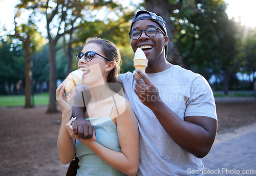 Image of Love, ice cream or couple of friends in a park walking on a romantic date in nature in an interracial relationship. Romance, black man and happy woman eating or enjoying a snack on a holiday vacation