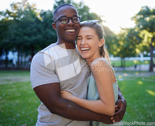 Image of Love, interracial or couple of friends hug in a park on a happy romantic date bonding in nature together. Romance, funny black man and woman laughing or enjoying quality time on a holiday vacation