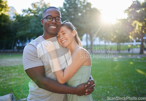 Image of Love, hug or couple of friends in a park on a relaxing romantic date in nature in an interracial relationship. Bonding, black man and happy woman enjoying quality time on a holiday vacation together