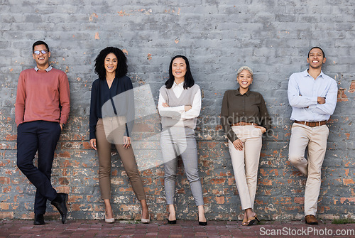 Image of Portrait, collaboration and goals with a business team standing together, leaning on a brick wall. Teamwork, mindset and vision with a man and woman employee group outside for future success