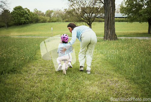 Image of Mother, girl and learning with bicycle in park with love, bonding or happy by grass field on holiday. Mama, kid and teaching, cycling and bike on outdoor adventure, woods or backyard garden in nature