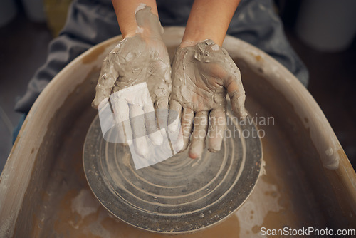 Image of Hands, clay and pottery wheel in a workshop after creating a sculpture or project for a small business. Creative, crafts and artistic sculptor manufacturing handicraft mould products in an art studio