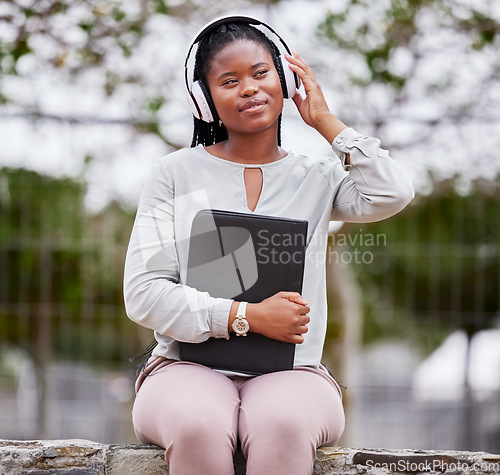 Image of Headphones, black woman and outdoor for peace, happiness and audio with young student calm in park. African American female, lady or girl with folder, headset for podcast or streaming music in nature