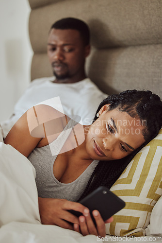 Image of Couple in bed, black woman with smartphone and nosy man, cheating and suspicion for affair, unfaithful and infidelity. Partners in bedroom, male and female with cellphone, chatting and jealous guy