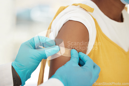 Image of Covid, vaccine and bandaid on the arm of a black woman patient in a hospital for an injection or healthcare. Doctor, medical and insurance with a female in a clinc for her corona virus vaccination