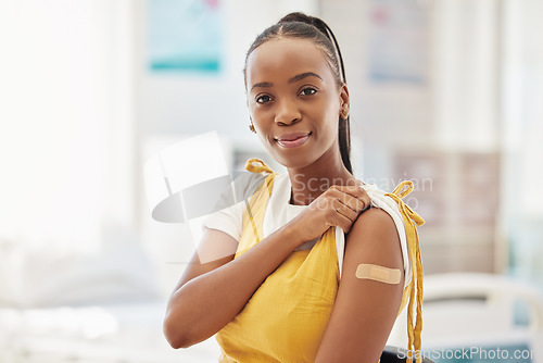 Image of Portrait, covid or vaccine and a black woman with a plaster on arm sitting in a hospital. Medical, insurance or healthcare and a female in a clinic with a bandaid on shoulder for corona vaccination