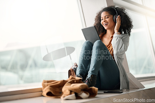 Image of Travel tablet, music headphones and black woman streaming radio or podcast. Technology, relax and happy female with touchscreen for social media app, networking and internet browsing at airport lobby