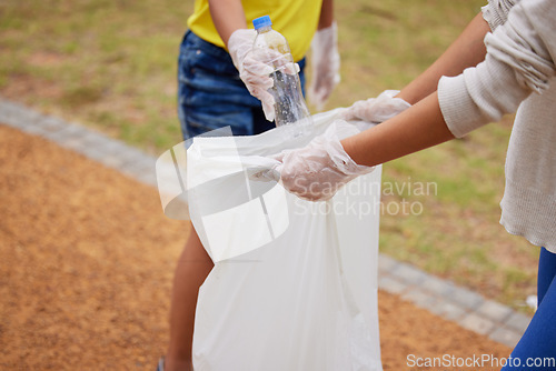 Image of Charity, earth day and volunteer cleaning trash for climate change outdoors at park to recycle for the environment. Planet, sustainability and community activists to pickup pollution, trash or litter