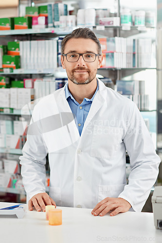 Image of Pharmacy, portrait and pharmacist man with pills bottle, medicine or product in retail or healthcare industry. Trust, help desk and medical professional worker with supplements stock or clinic drugs