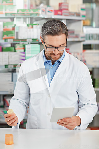 Image of Pharmacist man, store and reading with tablet, focus and medicine for marketing, pills or sales. Medical professional, pharma expert and mobile digital tech in pharmacy for wellness, health and care