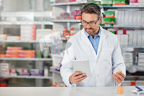 Image of Pharmacist man, shop and reading with tablet, medicine, pills and counter for health, medication or sales. Medical professional, pharma expert and mobile digital tech in pharmacy with wellness app