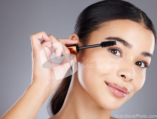 Image of Portrait, eyelash and brush for makeup, mascara and beauty with girl with grey studio background. Face, eyes and salon equipment for grooming routine, wellness and confidence with brows and cosmetics