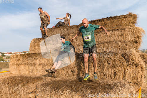 Image of Athletes overcoming the hay osbtacle