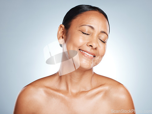 Image of Skincare, glow and face of a senior woman with beauty isolated on a blue background in studio. Smile, happy and elderly dermatology model with peace, cosmetic health and body wellness on a backdrop