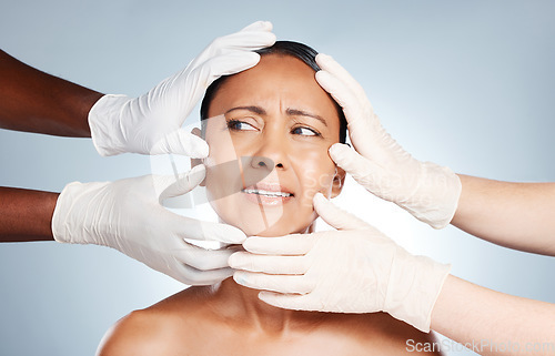 Image of Plastic surgery, confused and face of woman with hands from doctors isolated on blue background. Skincare, check and senior person worried about botox, cosmetic and facial surgery with professionals