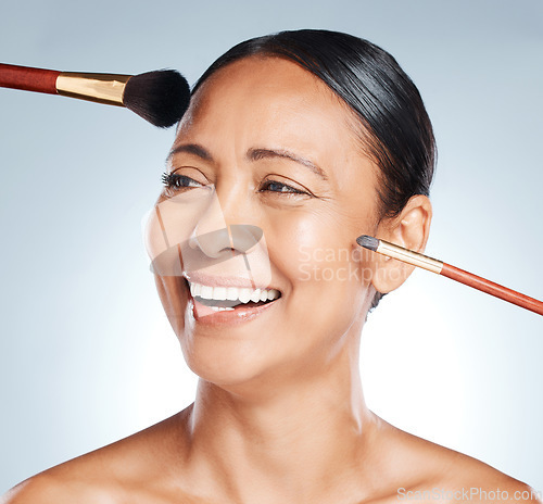 Image of Makeup, brushes and woman in a studio with a cosmetic, beauty and natural facial routine. Happy, smile and headshot of a mature female with face or skin cosmetics and brush posing by gray background.