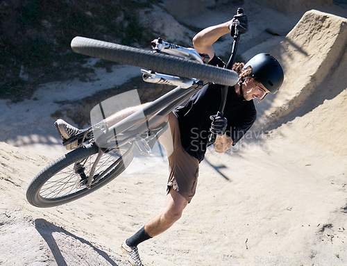 Image of Man, bike and sport trick in the dunes for fitness, parkour or cycling workout in nature outdoors. Male cyclist or biker in sports training, exercise or competition on safari dirt track with bicycle