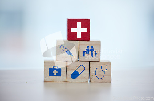 Image of Health, insurance and wooden blocks in studio on an empty gray background for safety or security. Abstract, medicine and healthcare with block toys in a hospital or clinic for medical care