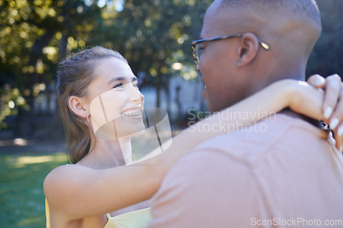 Image of Interracial couple, smile and hug for romantic love, care or embracing relationship in a nature park. Happy black man hugging woman and smiling in happiness for romance, embrace or support outside