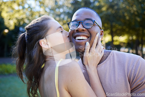Image of Woman kiss man, happiness and date in park, outdoor in nature with love and commitment in interracial relationship. Trust, support and happy couple, content with smile on face and fresh air